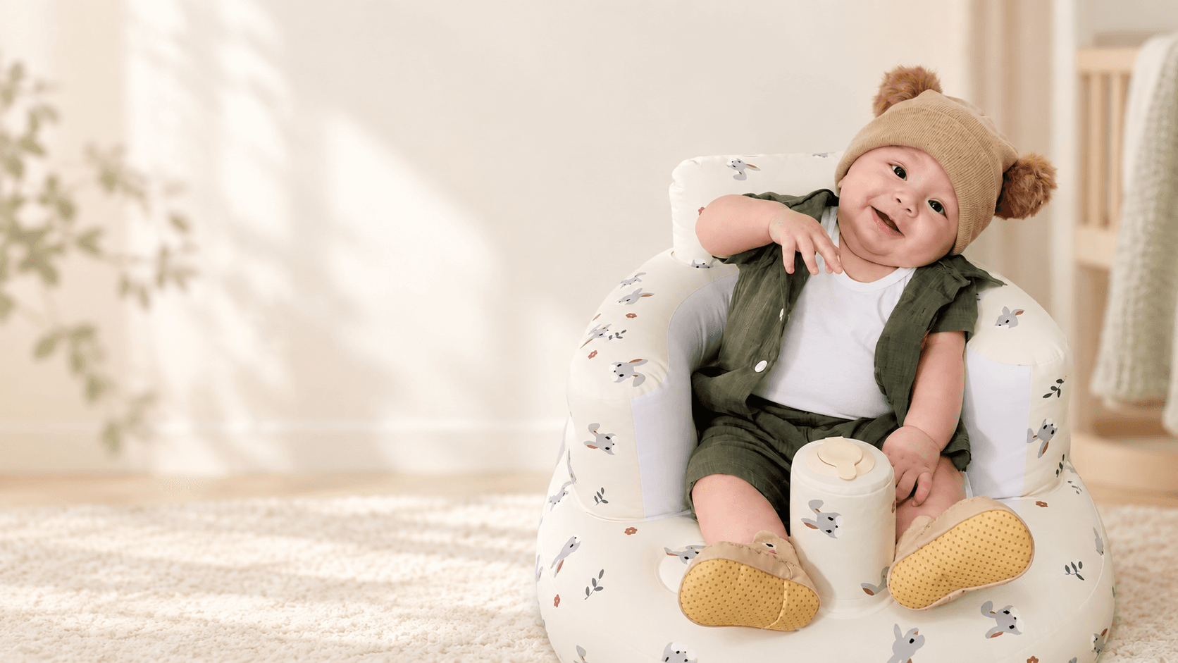 A smiling baby sitting comfortably in a nursery seat